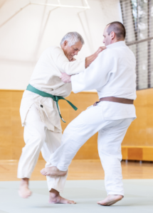 Deux judokas vétérans ceinture verte et ceinture marron font randori au dojo