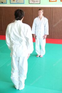 Deux judokas adultes ceintures blanches se prépare à saluer sur un tatami de judo